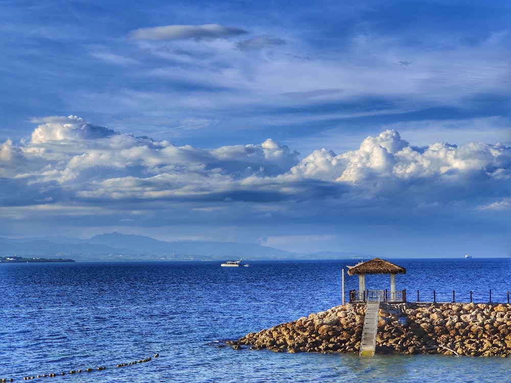 brown wooden house on gray rock formation near body of water during daytime