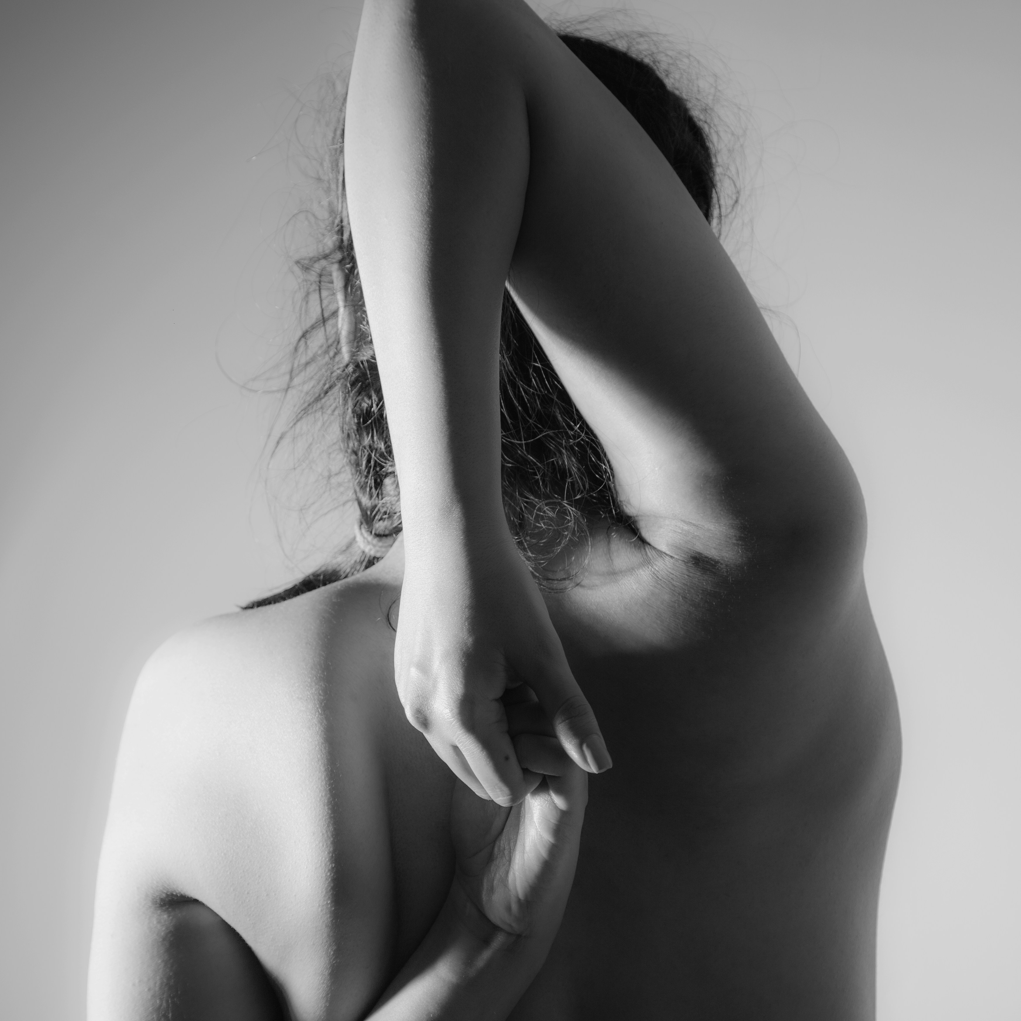 An artistic shot highlighting the interplay of shadows and browns on a strong, sculpted arm.