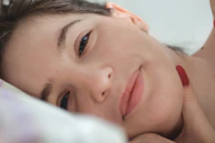 Close-up of a calm face practicing tapping in a softly lit room.