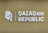 The image features a logo with the letters 'Q' and 'R' next to the text 'QAZAQ REPUBLIC' and the number '1465'. The background is a muted olive green color, and the text and logo are in a light, metallic shade.