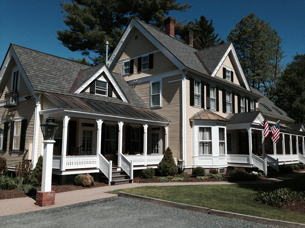 A large shingle-style house with a wraparound porch