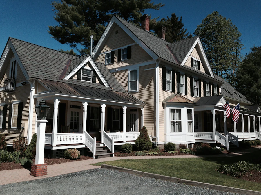 A large shingle-style house with a wraparound porch