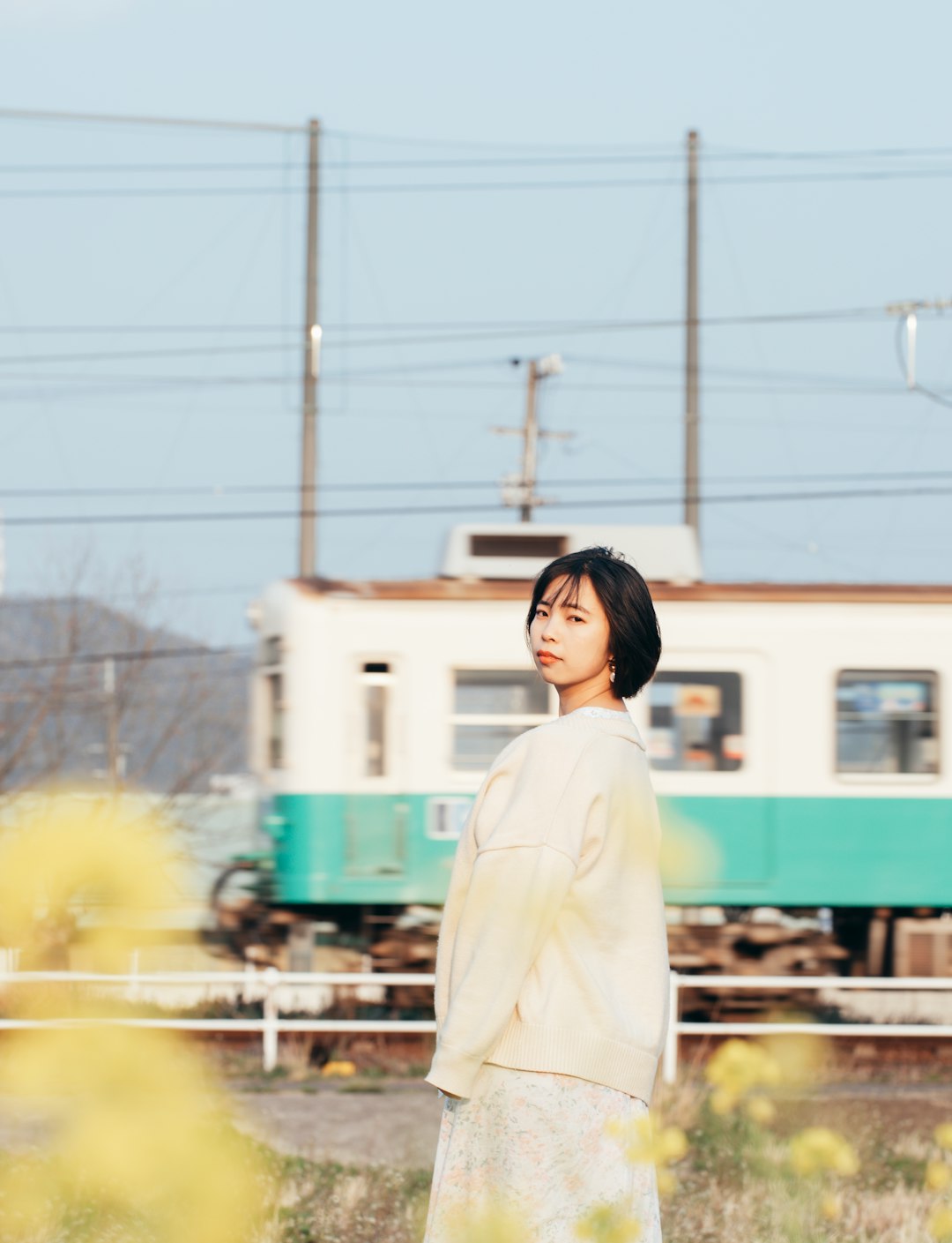 woman in white long sleeve shirt standing near train during daytime