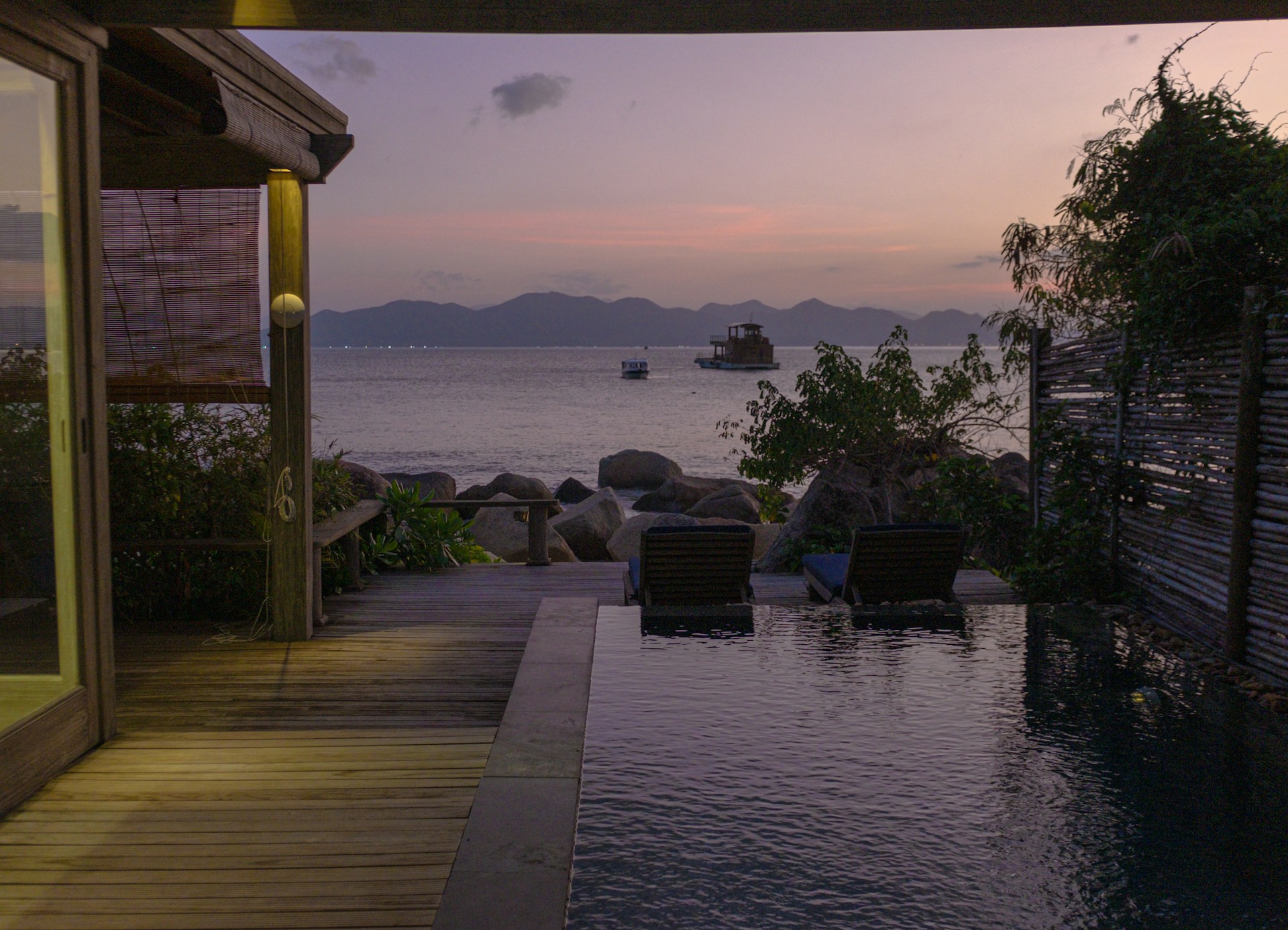 A serene outdoor living space with a sleek infinity pool, comfortable seating, and panoramic sunset views.