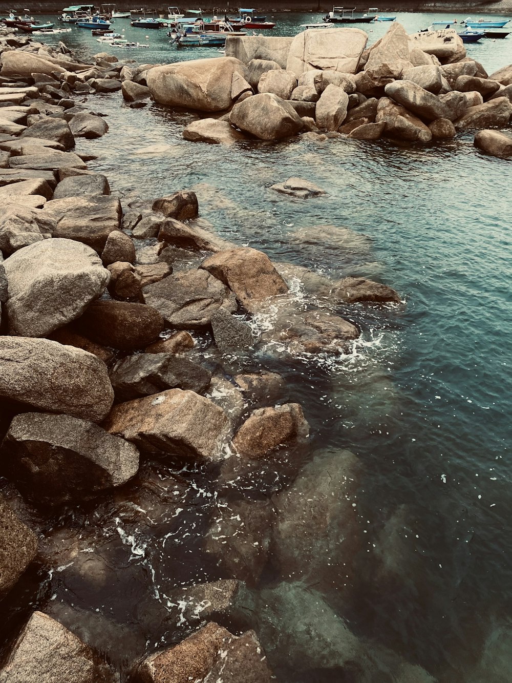 brown rocks beside body of water during daytime