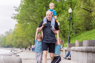 man in black crew neck t-shirt and green shorts standing on gray concrete floor during