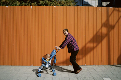 man in red and white plaid dress shirt and black pants riding blue and black kick
