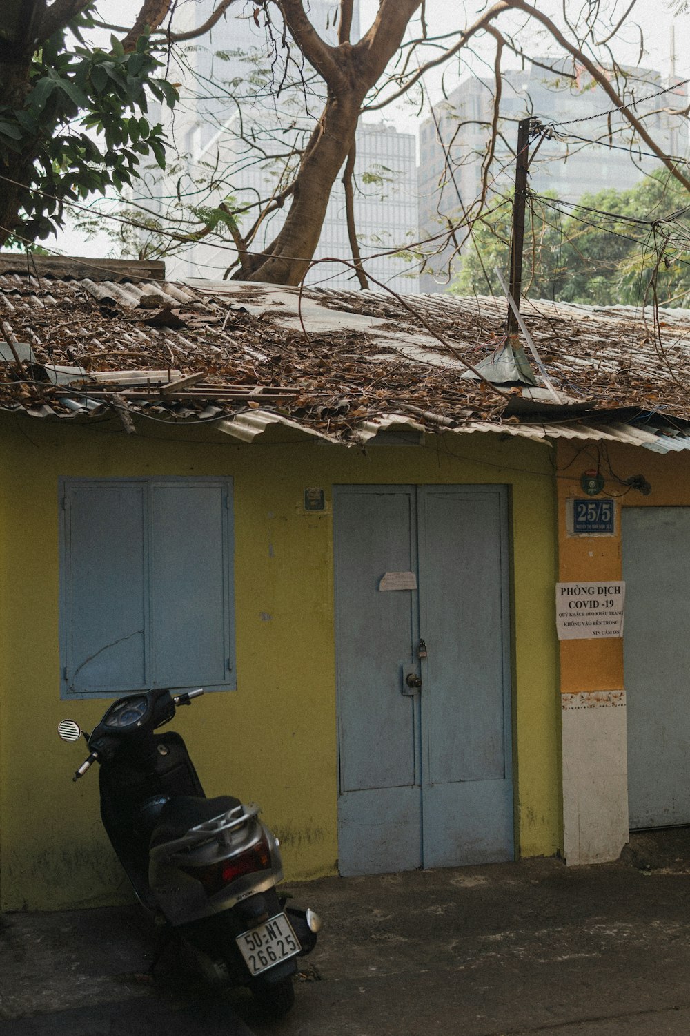 black motorcycle parked beside yellow and green concrete building