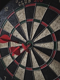 Close-up of a dartboard with colorful darts hitting the bullseye.
