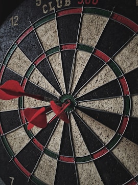 A close-up of a dart hitting the bullseye on a board.