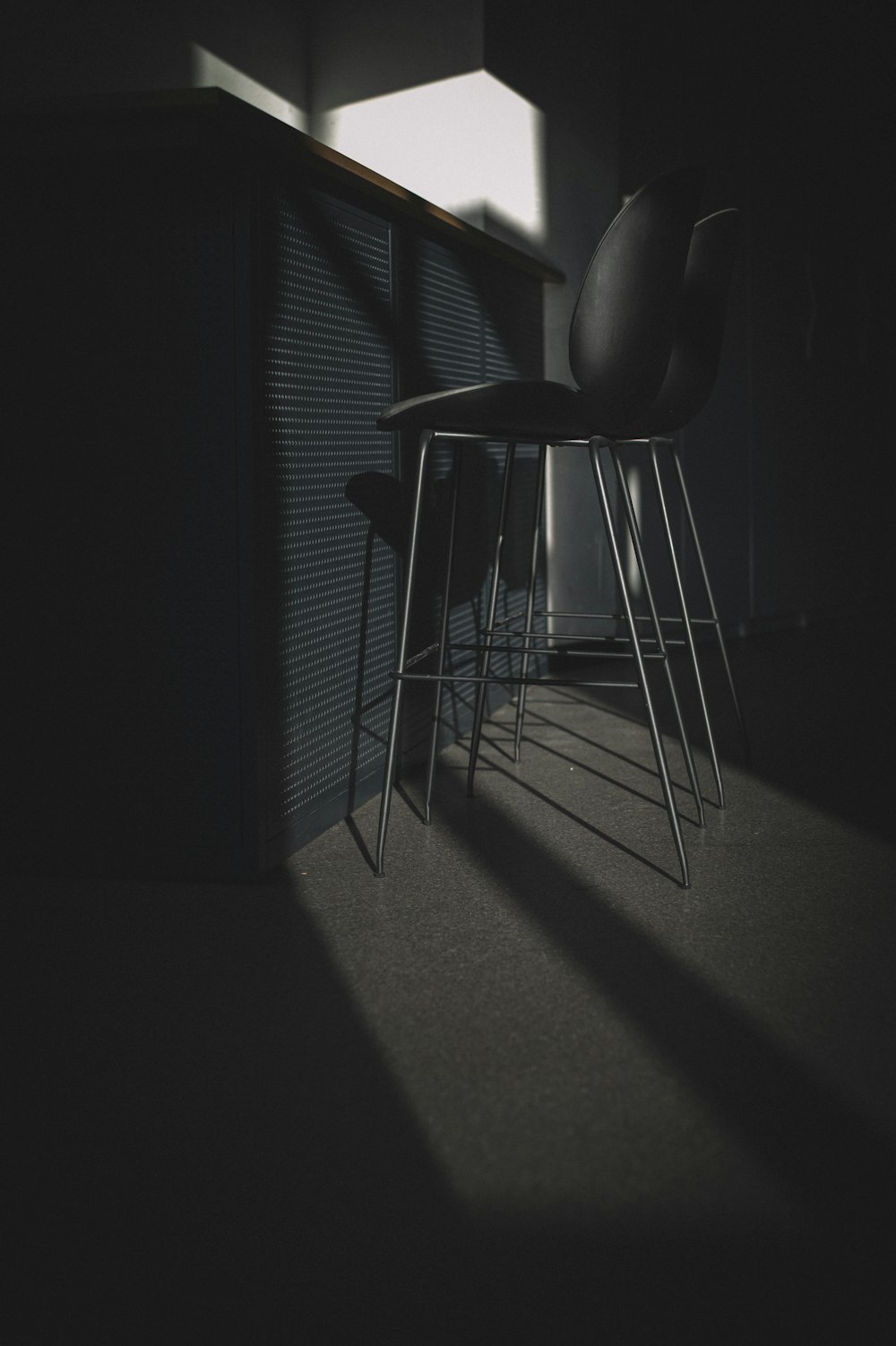cadeira acolchoada de couro preto perto da janela