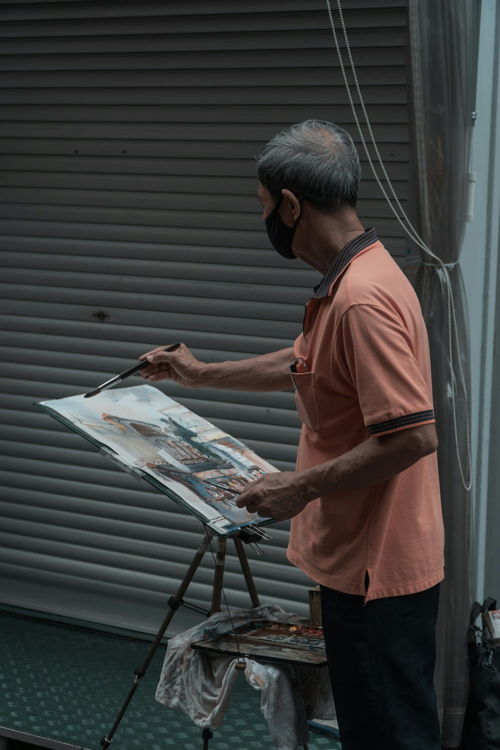 man in orange polo shirt reading newspaper