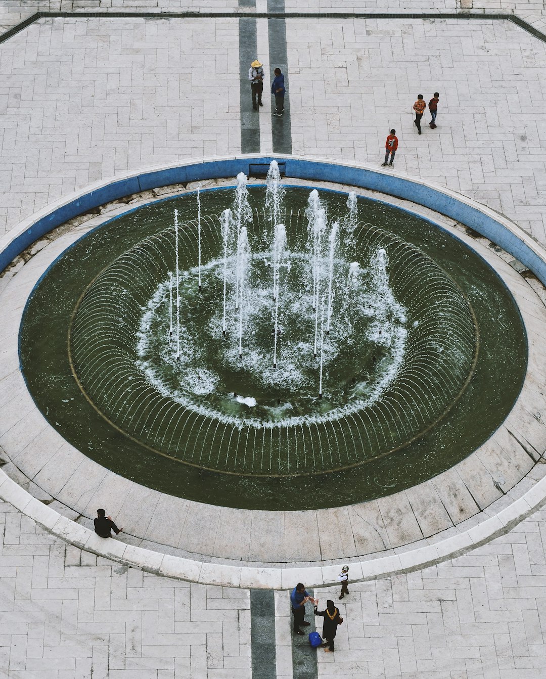 people standing on water fountain during daytime
