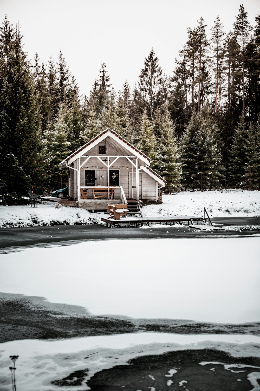 brown wooden house on snow covered ground near green trees during daytime