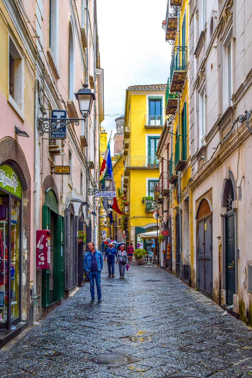 people walking on street between buildings during daytime