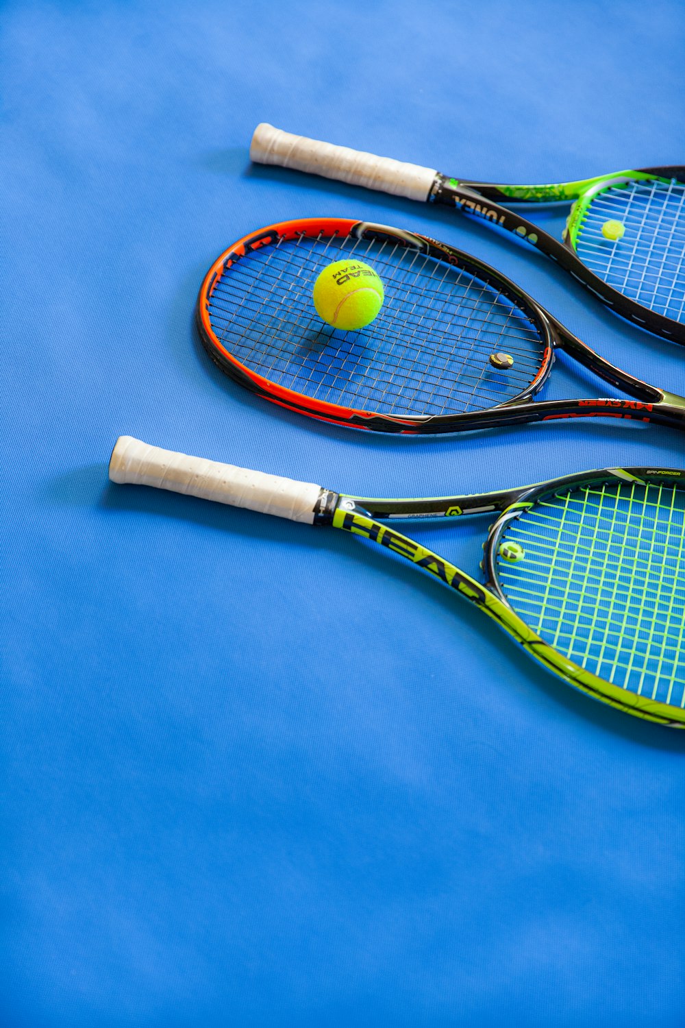 yellow and black tennis racket on blue textile