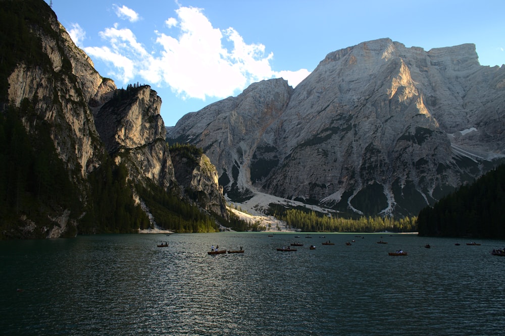 people riding boat on lake near mountain during daytime
