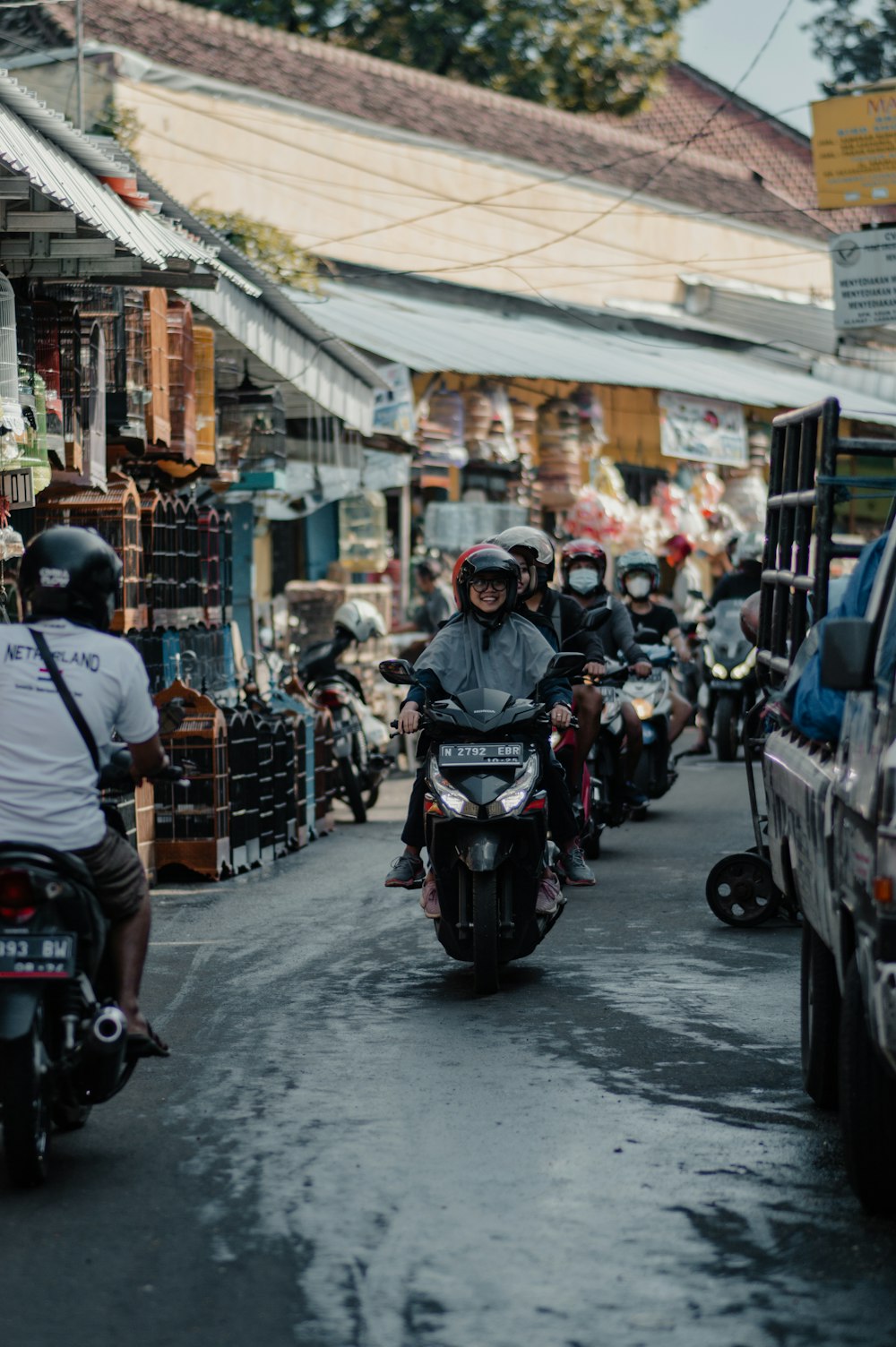 Personas que andan en motocicleta en la calle durante el día