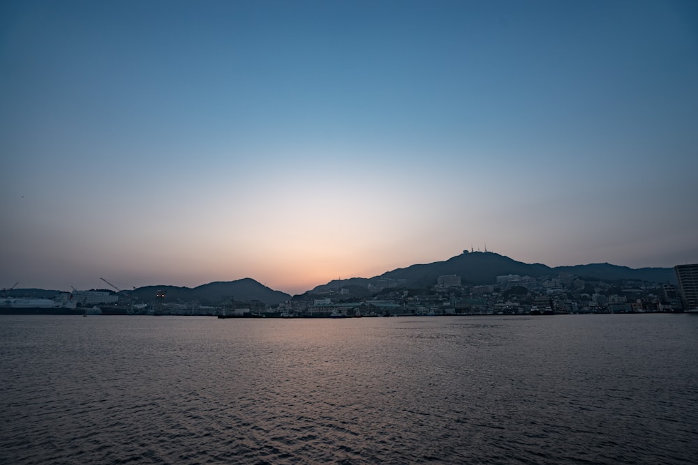 silhouette de montagne près du plan d’eau au coucher du soleil