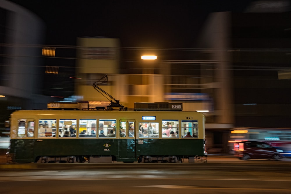 white and green train on rail during night time