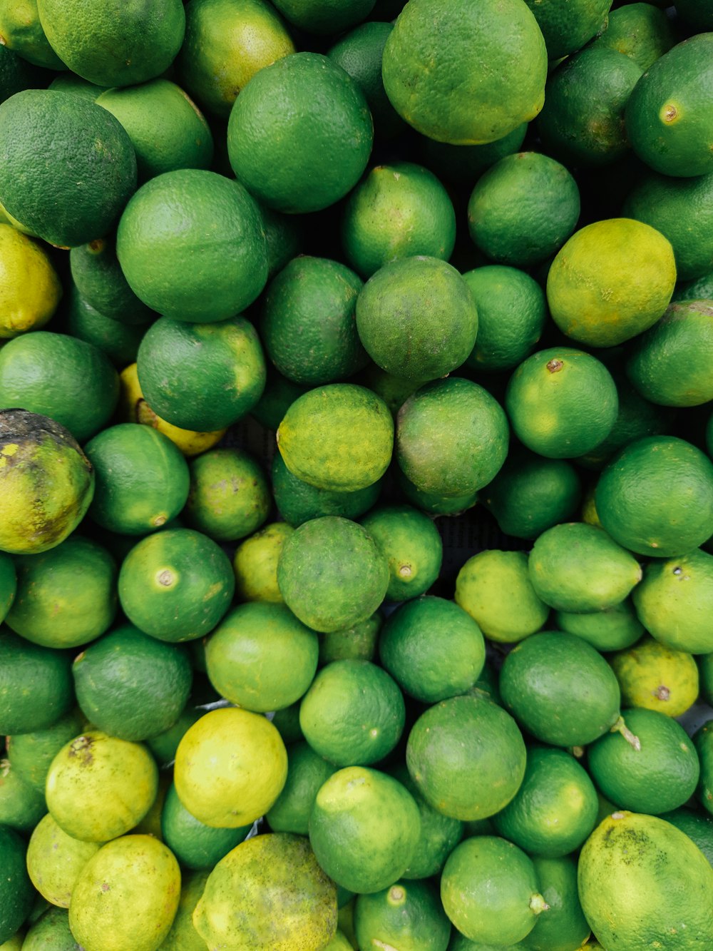 green round fruits on white surface