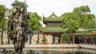 brown and green temple near body of water during daytime