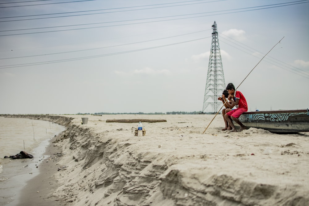 woman in pink shirt sitting on beach during daytime