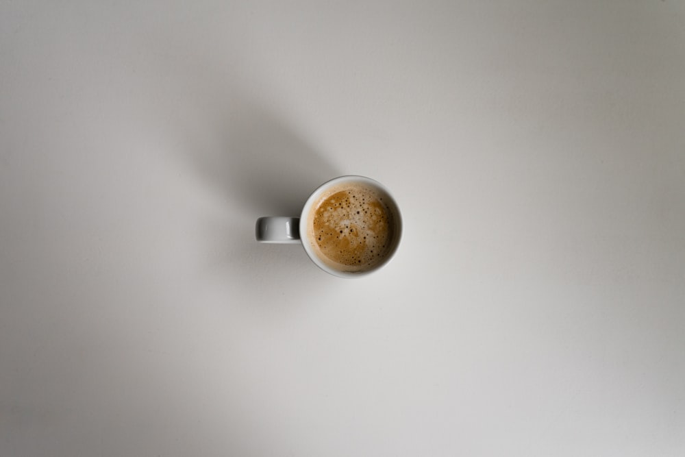 white ceramic mug on white table