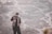 man in black coat standing on gray sand during daytime