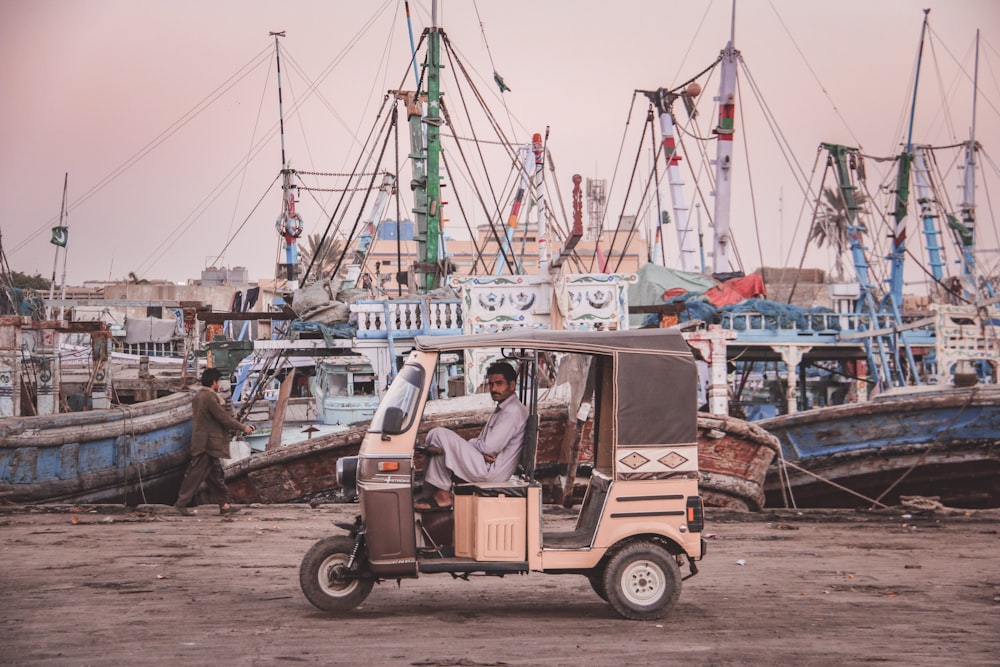 man in white shirt driving auto rickshaw