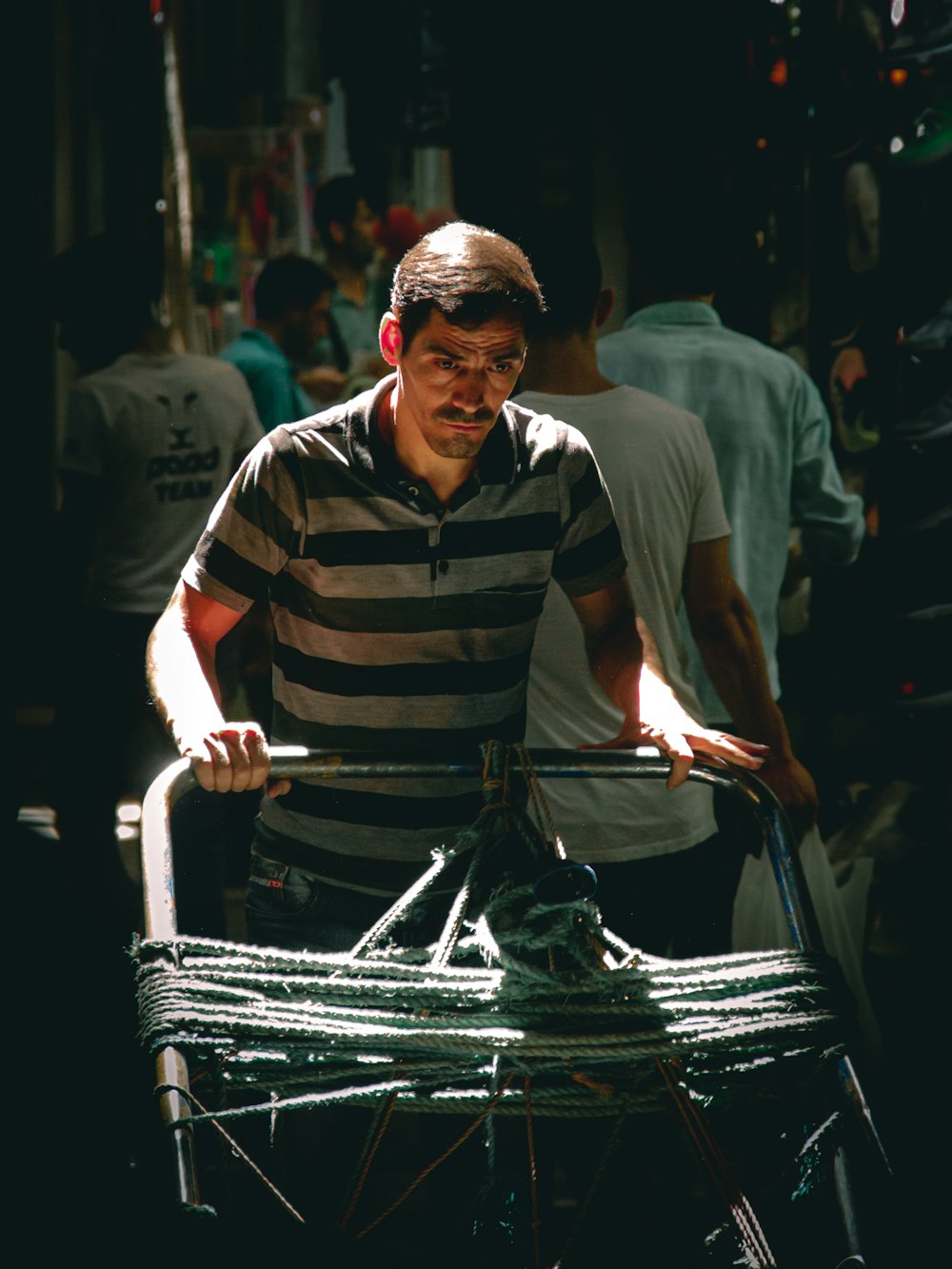 man in black and white stripe polo shirt holding black plastic bag