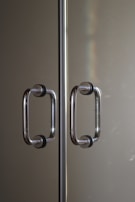 Modern stainless steel door handles shining under soft lighting.