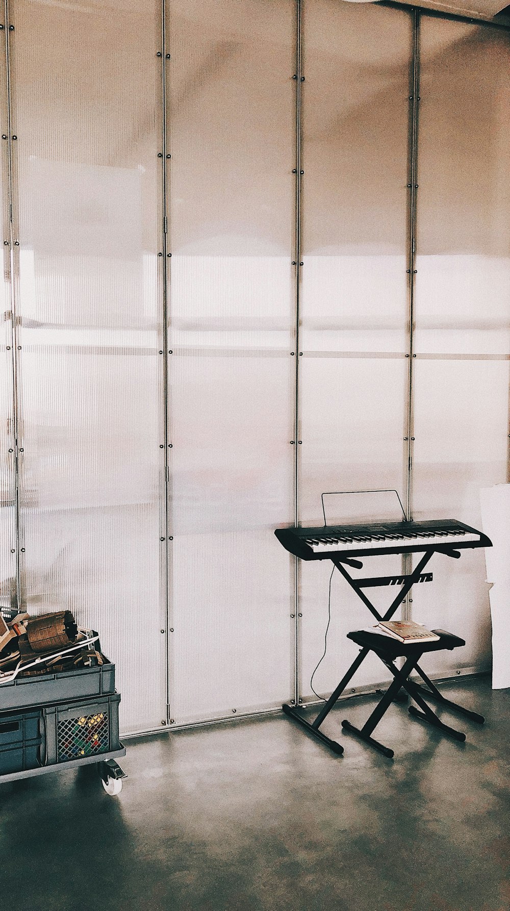 black and gray folding chair beside black and brown electric piano