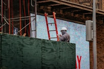 Construction workers using tablets on a site with a vintage filter effect.