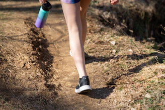 person in purple shorts and white socks holding purple bottle