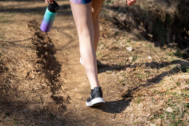 person in purple shorts and white socks holding purple bottle