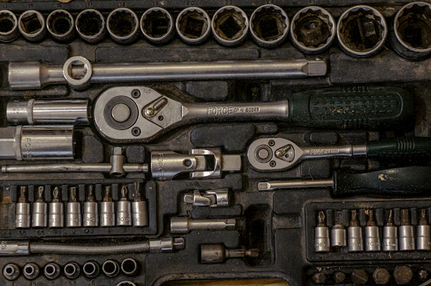 A sturdy metal garage tool chest with organized tools neatly arranged inside.