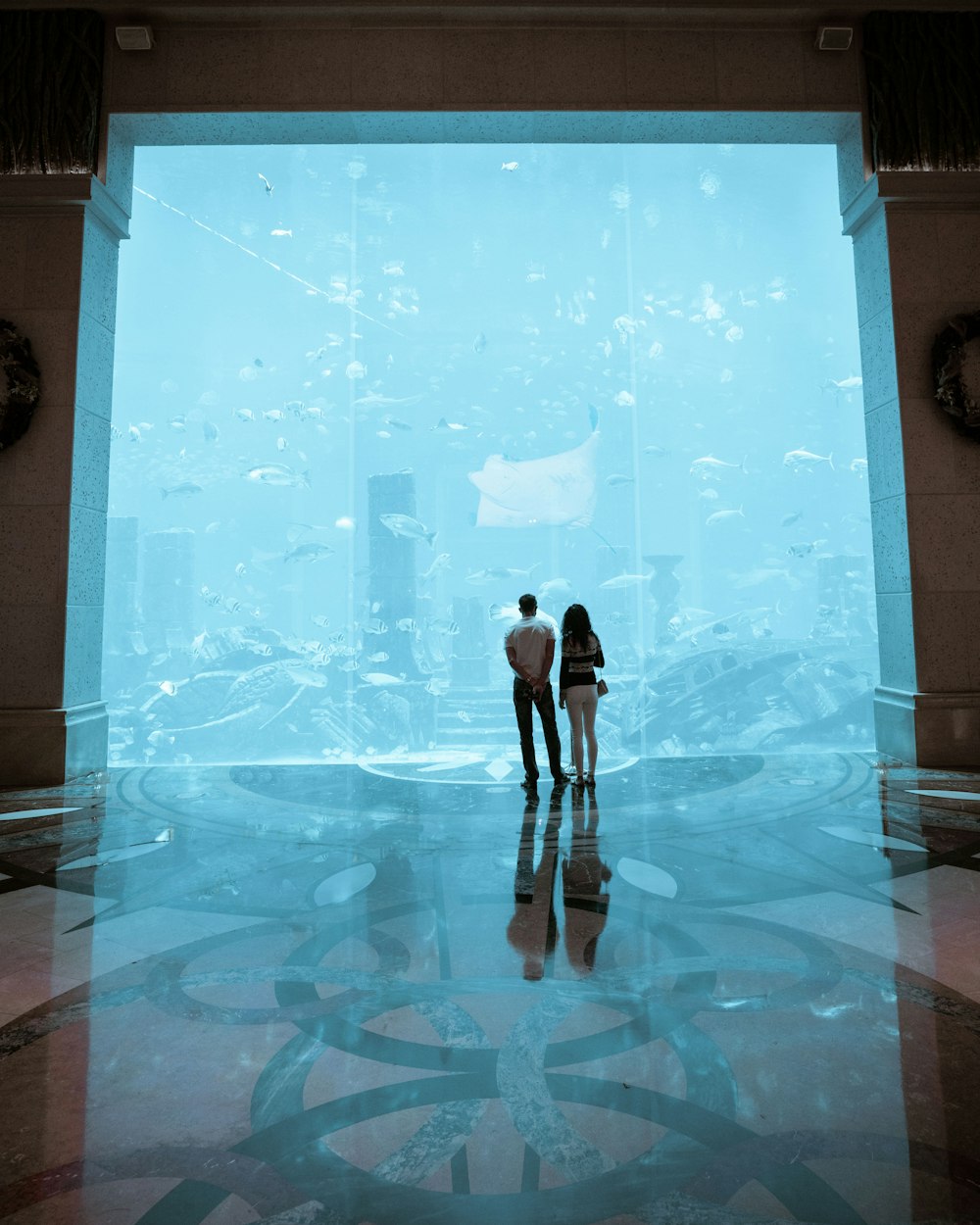 man and woman standing on blue and white floor tiles