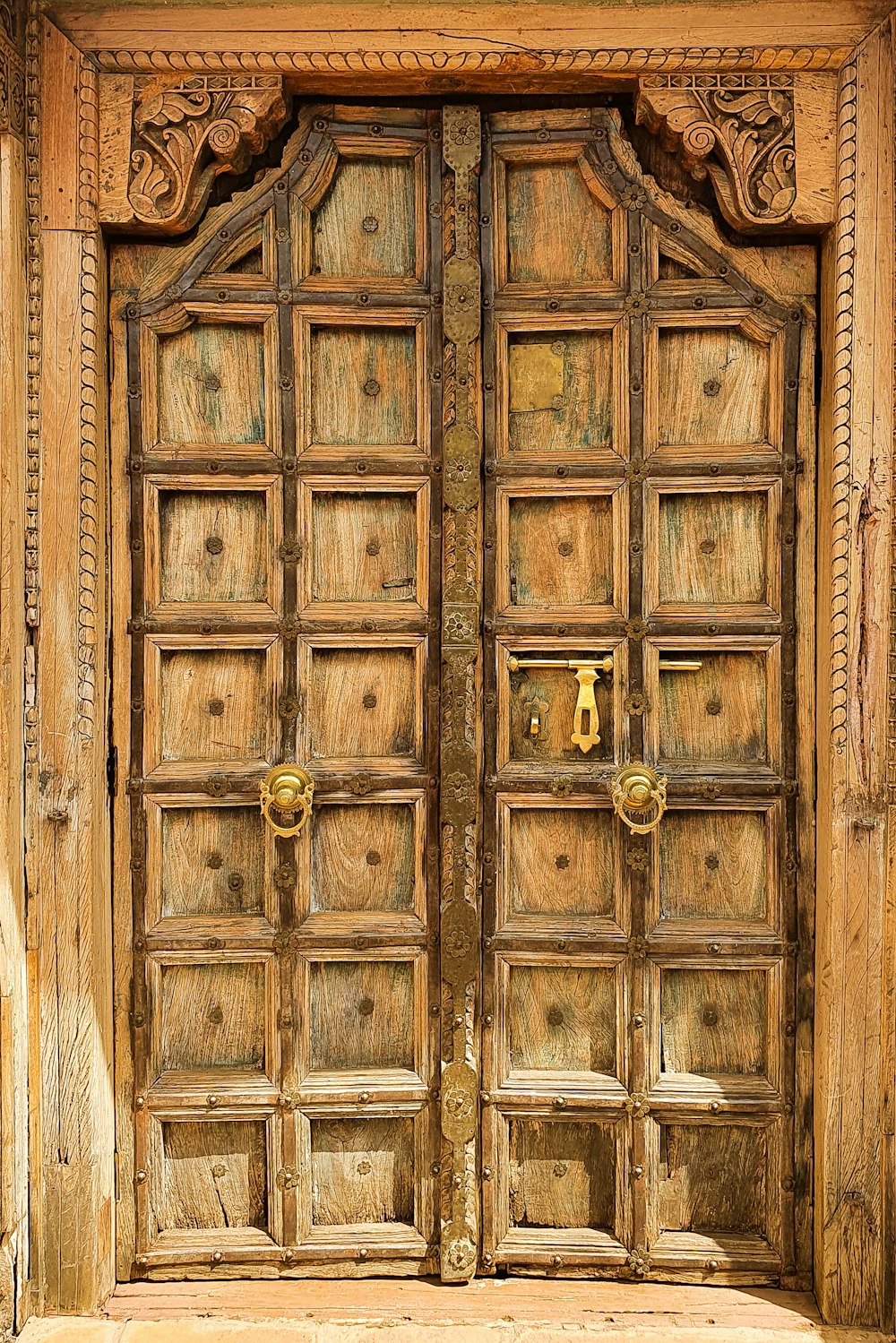 金のドアノブが付いている茶色の木のドア