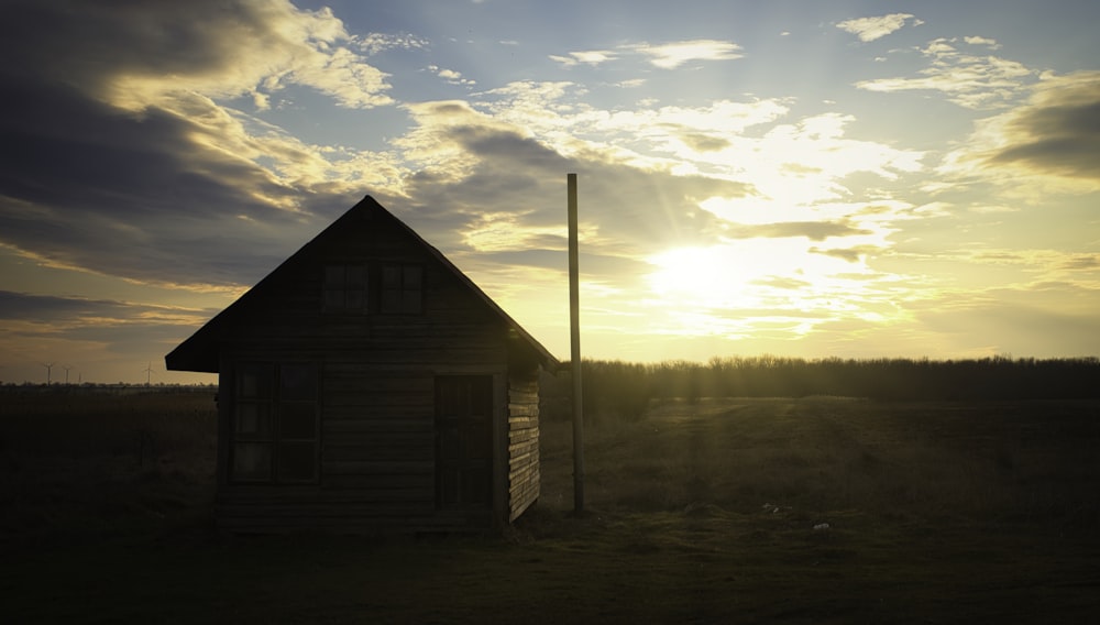 casa de madera marrón cerca de los árboles bajo las nubes blancas y el cielo azul durante el día