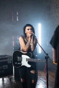 woman in black tank top singing on stage