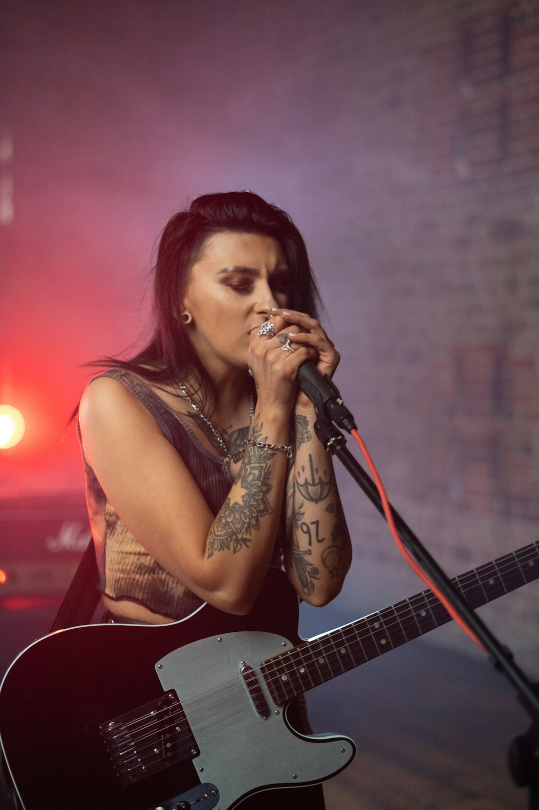 woman in brown tank top playing guitar