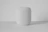 Close-up of a sleek smart home device glowing softly on a minimalist white shelf.
