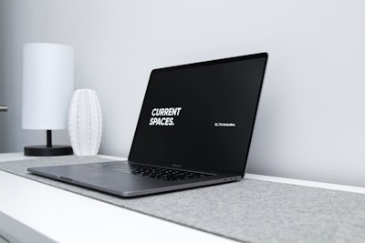 A sleek laptop screen showing a minimalist personal brand website layout.