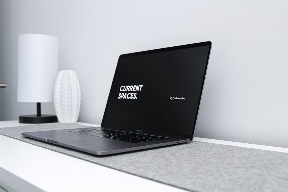 Computadora portátil Lenovo negra sobre mesa blanca