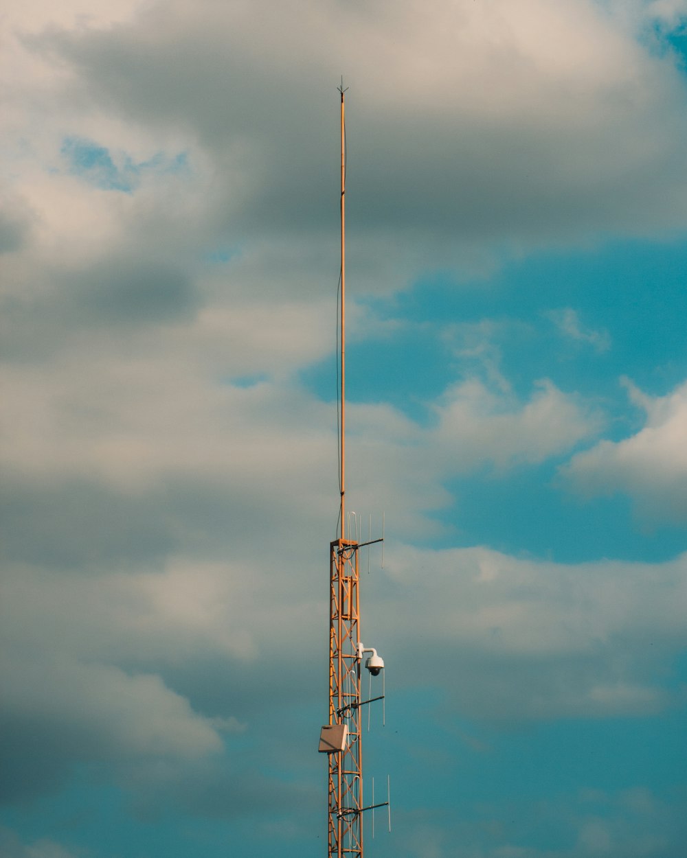 white and brown electric post under cloudy sky