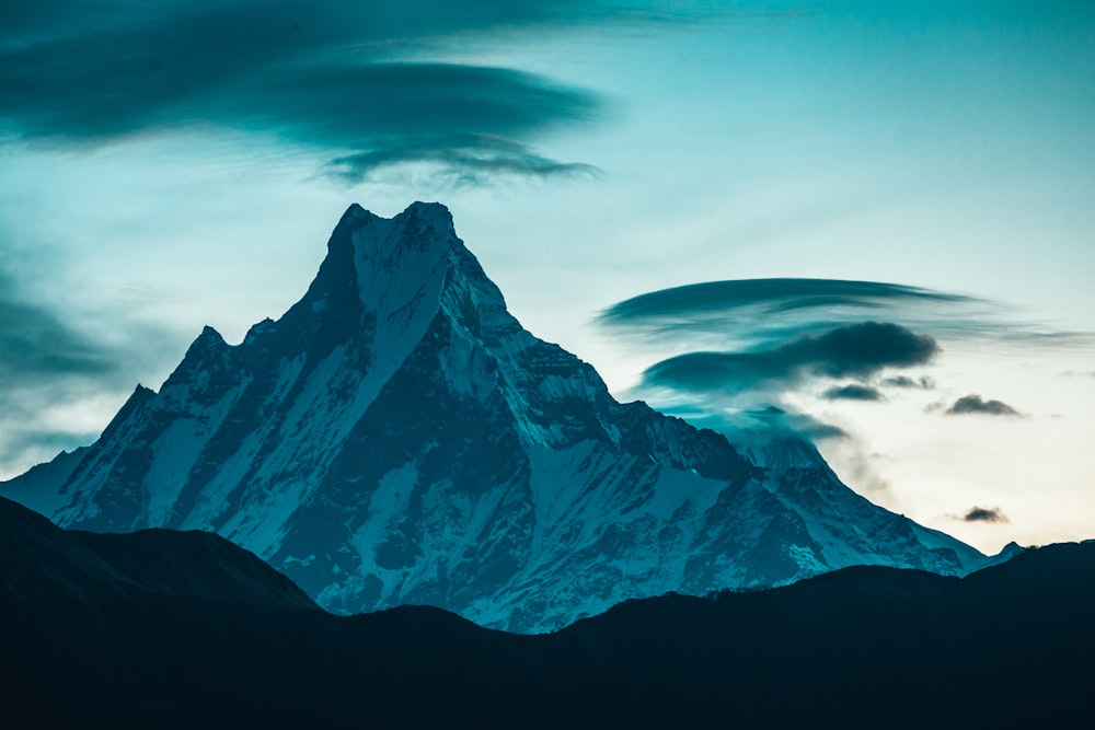 snow covered mountain under cloudy sky