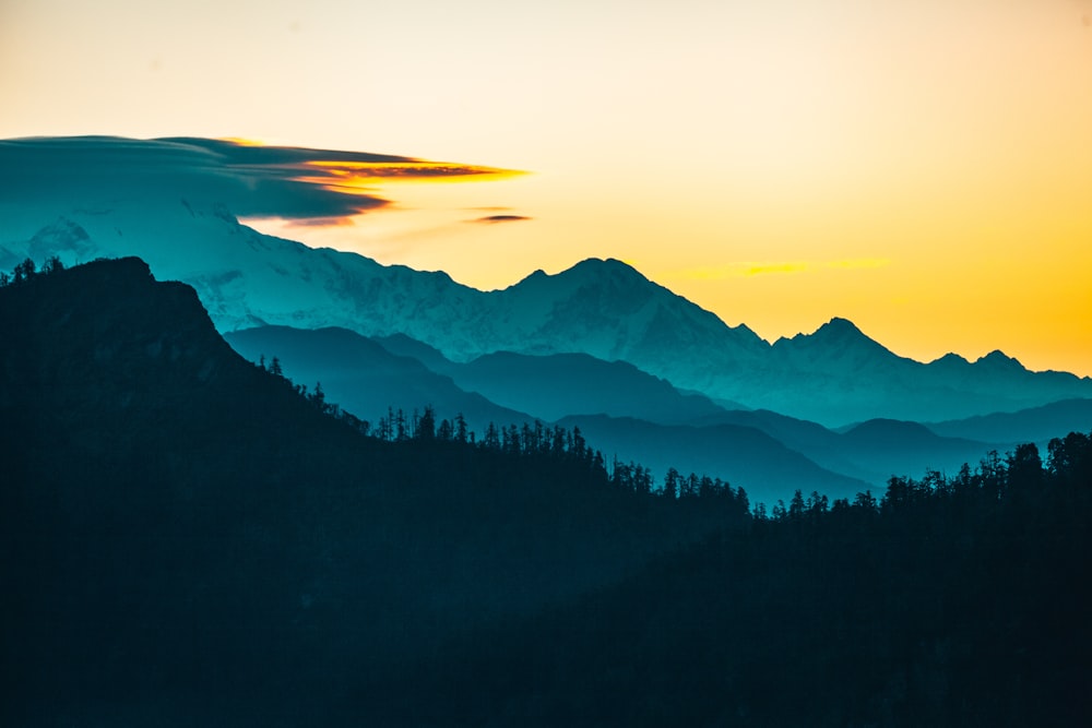 silhouette of trees and mountains during sunset