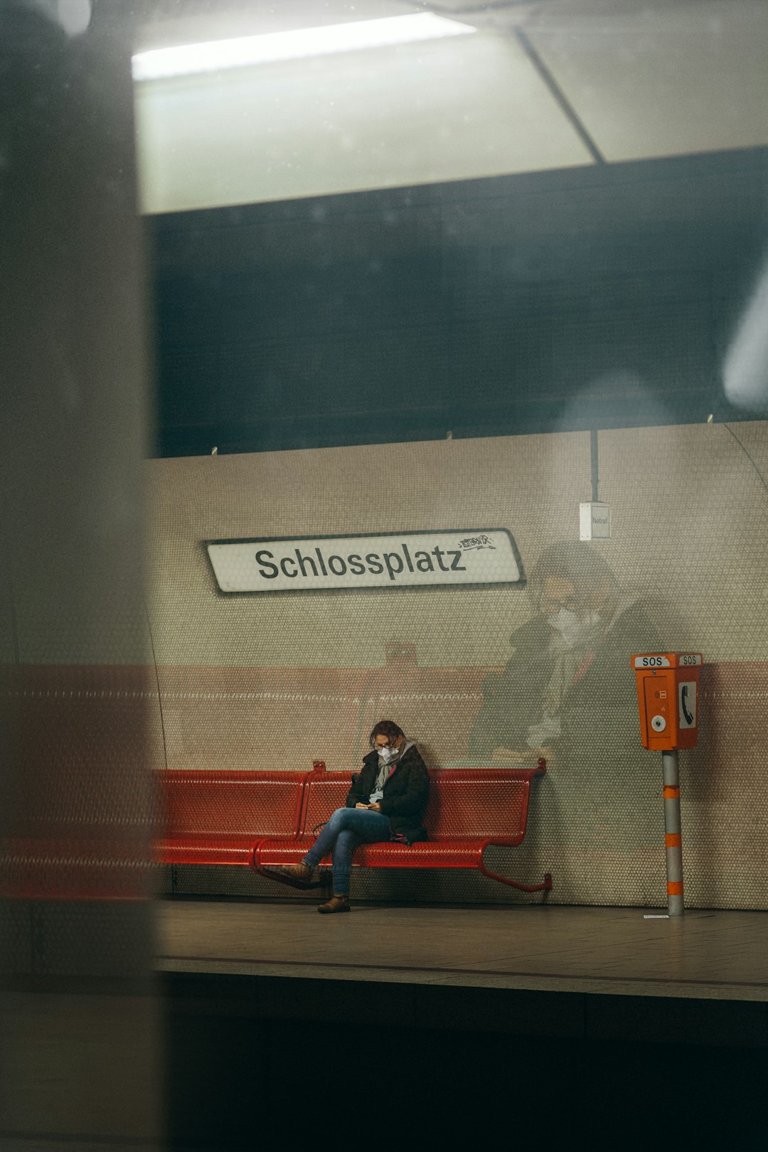 man in black jacket sitting on red chair