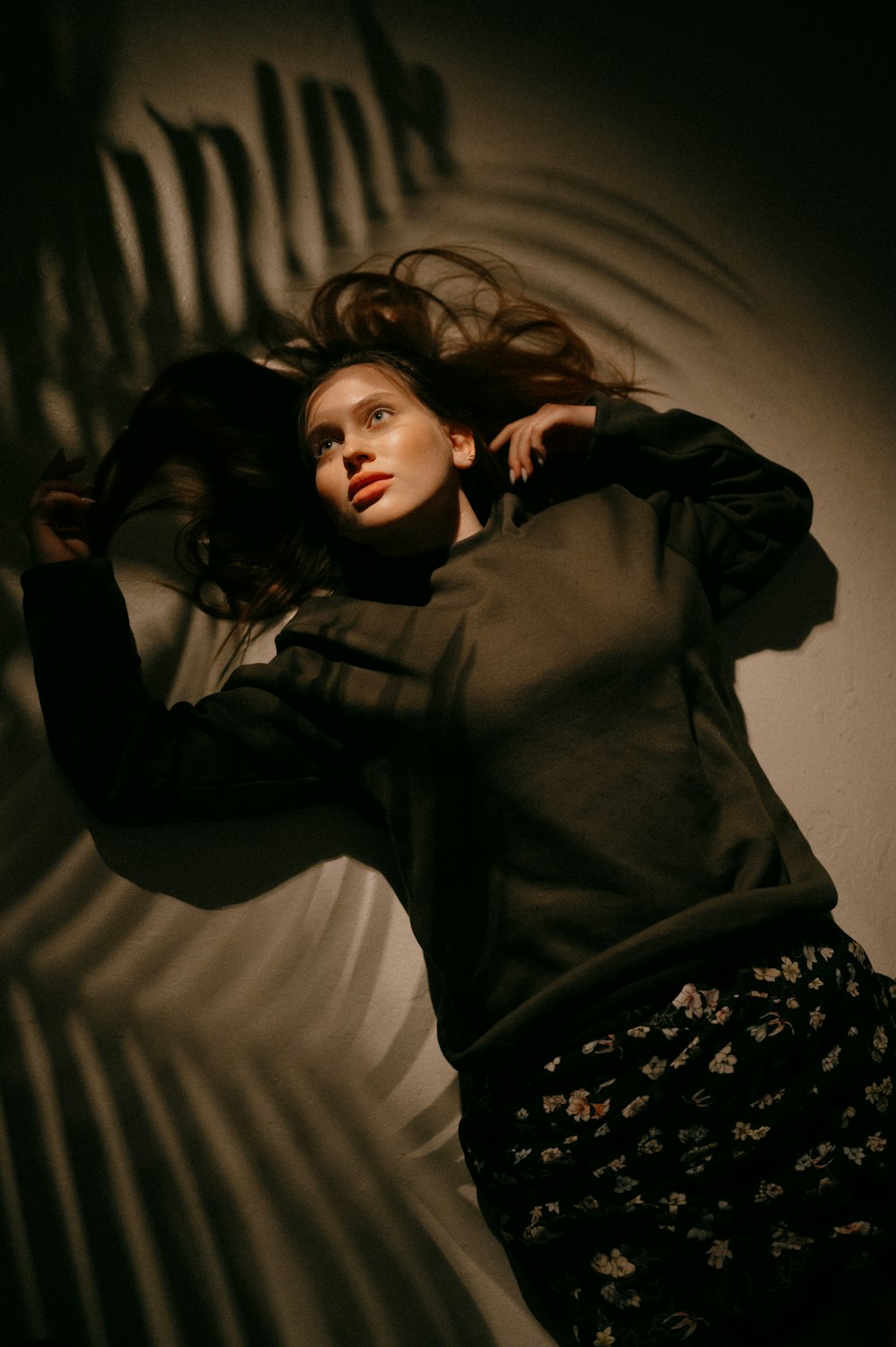 woman in black long sleeve shirt lying on bed